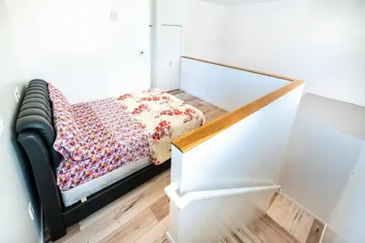 a small bedroom with a bed with a flowered blanket at New York loft- style 3 levels 2 Bath by Hollywood in Los Angeles