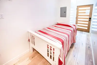 a small bedroom with a bed with a striped blanket at New York loft- style 3 levels 2 Bath by Hollywood in Los Angeles