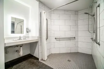 a white bathroom with a sink and a shower at ERTH INN by AGA- Bell Garden in Bell Gardens