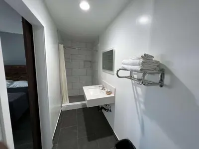 a white bathroom with a sink and a mirror at ERTH INN by AGA- Bell Garden in Bell Gardens