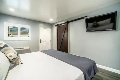 a bedroom with a bed and a tv on the wall at ERTH INN by AGA- Bell Garden in Bell Gardens