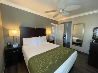 a hotel room with a bed and a ceiling fan at Hi View Inn & Suites in Manhattan Beach