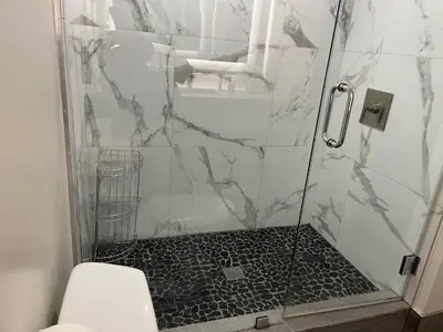 a bathroom with a shower with a black and white at Hi View Inn & Suites in Manhattan Beach