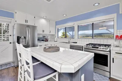 a kitchen with white cabinets and a white counter top at North Shore Chalet by Big Bear Vacations Lakeside Fawnskin Estate Boat Dock Lake Access in Fawnskin