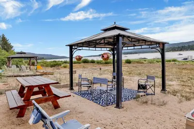 a picnic table and chairs under a gazebo at North Shore Chalet by Big Bear Vacations Lakeside Fawnskin Estate Boat Dock Lake Access in Fawnskin