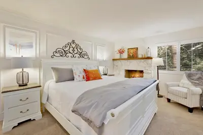 a white bedroom with a bed and a fireplace at Soaring Pines by Big Bear Vacations Central Cozy Estate Chalet in Big Bear Lake