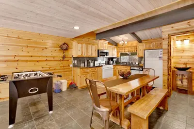 a kitchen with wooden walls and a wooden table and chairs at Smith Chalet at Snow Summit- Furnished Resort Condo- Foosball- Walk To Lifts in Big Bear Lake