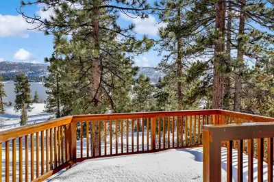 a wooden deck in the snow with a bench at Cozy Lakeview Hideaway by Big Bear Vacations Amazing Fawnskin Log Cabin Chalet in Fawnskin