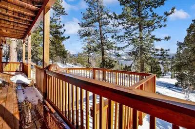 a deck of a cabin with snow on the ground at Cozy Lakeview Hideaway by Big Bear Vacations Amazing Fawnskin Log Cabin Chalet in Fawnskin