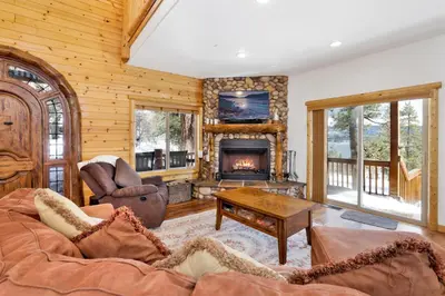 a living room with a couch and a fireplace at Cozy Lakeview Hideaway by Big Bear Vacations Amazing Fawnskin Log Cabin Chalet in Fawnskin