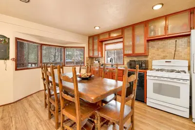 a kitchen with a wooden dining room table and chairs at Swiss Delight by Big Bear Vacations Hot Tub Game Tables Central in Big Bear Lake