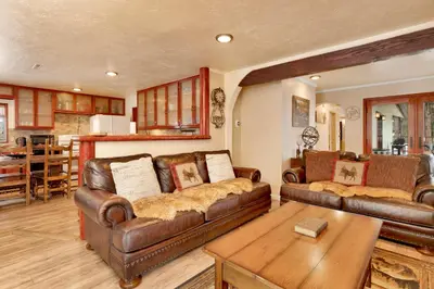 a living room with two leather couches and a table at Swiss Delight by Big Bear Vacations Hot Tub Game Tables Central in Big Bear Lake