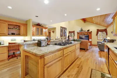 a kitchen with wooden cabinets and a counter top at Fawnskin Log Cabin- Luxurious Group Log Cabin Estate- Hot Tub- Walk to Lake in Fawnskin