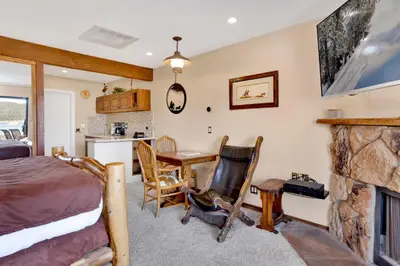 a bedroom with a bed and a desk and a fireplace at Forest Shores Lake View Condo by Big Bear Vacations Lakefront Village in Big Bear Lake