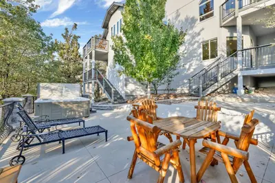 a patio with a wooden table and chairs at Sunset Ridge Villa- Incredible Log Cabin Estate- Hot Tub- Game Tables- in Big Bear Lake