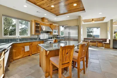 a large kitchen with wooden cabinets and a large island at Sunset Ridge Villa- Incredible Log Cabin Estate- Hot Tub- Game Tables- in Big Bear Lake