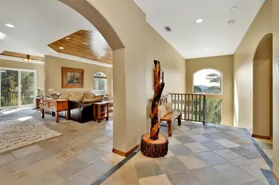a living room with an arched ceiling and a living room with a table at Sunset Ridge Villa- Incredible Log Cabin Estate- Hot Tub- Game Tables- in Big Bear Lake