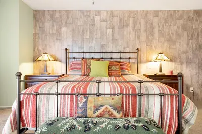 a bedroom with a large bed with two lamps at Brownie's Den- Modern Cozy Central Resort Condo in Big Bear Lake