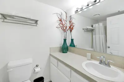 a bathroom with a sink and a vase with flowers in it at Brownie's Den- Modern Cozy Central Resort Condo in Big Bear Lake