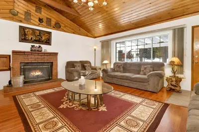 a living room with a couch and a table and a fireplace at Cozy Summit- Cozy Central Resort Chalet- Minutes to Activities in Big Bear Lake