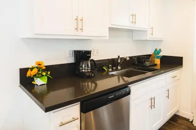 a kitchen with white cabinets and a stainless steel dishwasher at Nice and Close to Downtown 1 Bedroom Sleeps 4 in Los Angeles