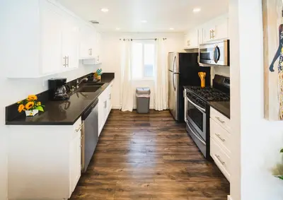a kitchen with white cabinets and black appliances at Nice and Close to Downtown 1 Bedroom Sleeps 4 in Los Angeles