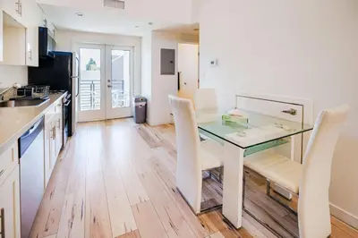 a kitchen with a glass table and white chairs at Chic 1-Bed Hollywood Loft Iconic Sign Views & Private Parking in Los Angeles