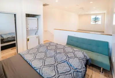 a small bedroom with a bed and a kitchen at Chic 1-Bed Hollywood Loft Iconic Sign Views & Private Parking in Los Angeles