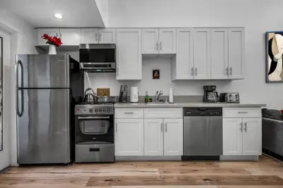 a kitchen with white cabinets and stainless steel appliances at New 1 Bedroom Loft with View of Hollywood Sign in Los Angeles