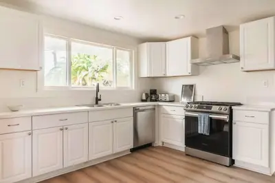 a kitchen with white cabinets and a black stove top oven at 30 PCT OFF! Malibu Villa, Ocean View, Beach, Hiking in Malibu