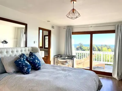 a bedroom with a bed with blue pillows and a balcony at Malibu Ocean Villa with King Bed, Hot Tub, Beach, BBQ in Malibu