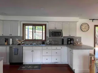 a kitchen with white cabinets and a clock on the wall at Malibu Ocean Villa with King Bed, Hot Tub, Beach, BBQ in Malibu