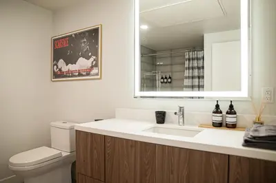 a bathroom with a sink and a toilet and a mirror at Luxury Apartment With The Hollywood Hills View in Los Angeles