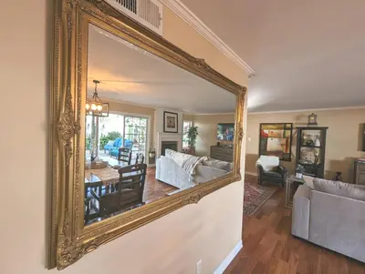 a large gold mirror on the wall of a living room at 4 BR Encino Home w/ Amazing Yard, Near Everything in Encino