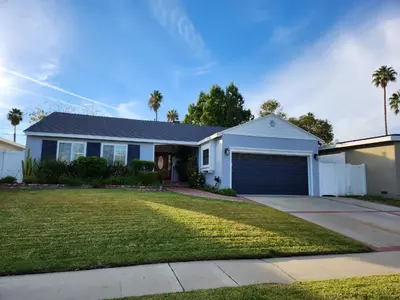 a white house with a garage and palm trees at 4 BR Encino Home w/ Amazing Yard, Near Everything in Encino