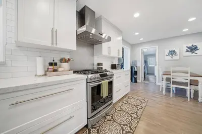 a kitchen with white cabinets and a stove top oven at Private Heated Pool Oasis/Disney/Retro Arcade/Gym in Placentia