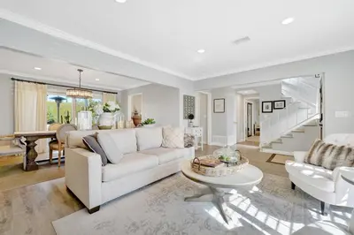 a living room with a white couch and a table at Private Heated Pool Oasis/Disney/Retro Arcade/Gym in Placentia