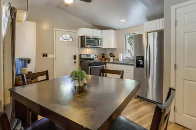 a kitchen with a table and a stainless steel refrigerator at Less Than 1 Mi to Big Bear Lake Fawnskin Cottage with Grill in Fawnskin