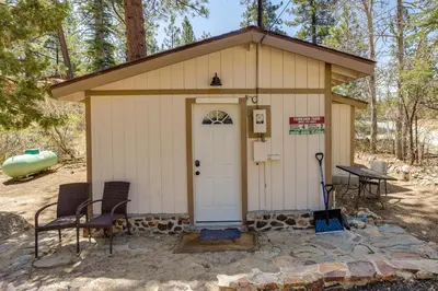 a small shed with a white door and two chairs at Less Than 1 Mi to Big Bear Lake Fawnskin Cottage with Grill in Fawnskin