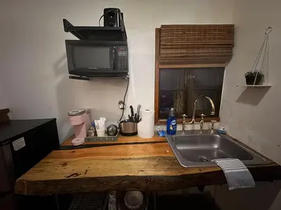 a kitchen counter with a sink and a microwave at Three Pines Cabins in Big Bear Lake