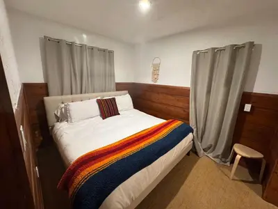 a bedroom with a bed with a colorful blanket on it at Three Pines Cabins in Big Bear Lake