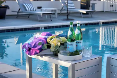 two bottles of beer sitting on a table next to a swimming pool at Downtown LA's Most Requested Property, Sleeps 4 with Free Parking! in Los Angeles