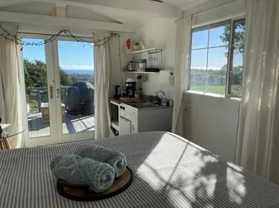 a bedroom with a bed and a kitchen with windows at 30 PCT OFF! Malibu Charming Suite, Ocean View, King Bed in Malibu