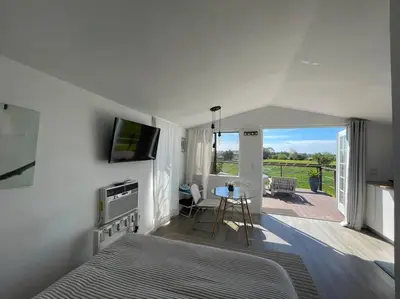 a bedroom with a bed and a television and a patio at 30 PCT OFF! Malibu Serene Cabin, Ocean View, Beach in Malibu