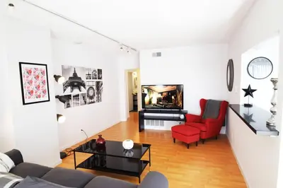 a living room with a couch and red chairs at Hollywood Business Apartments in Los Angeles