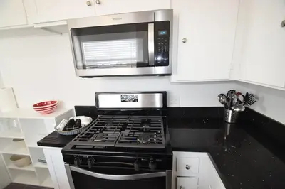 a kitchen with a stove and a microwave at Hollywood Business Apartments in Los Angeles