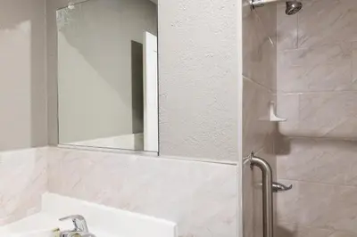 a bathroom with a sink and a shower with a mirror at Starlite Motel in San Bernardino