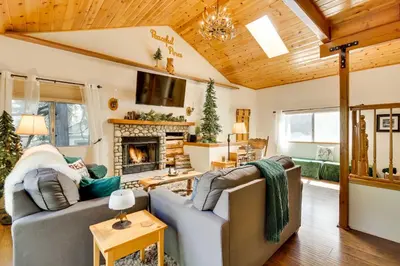 a living room with a couch and a fireplace at Peaceful Pines Running Springs Home with 3 Decks in Running Springs