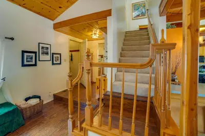 a spiral staircase in a home with wooden floors at Peaceful Pines Running Springs Home with 3 Decks in Running Springs