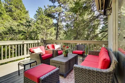 a porch with wicker chairs and tables on a deck at Peaceful Pines Running Springs Home with 3 Decks in Running Springs